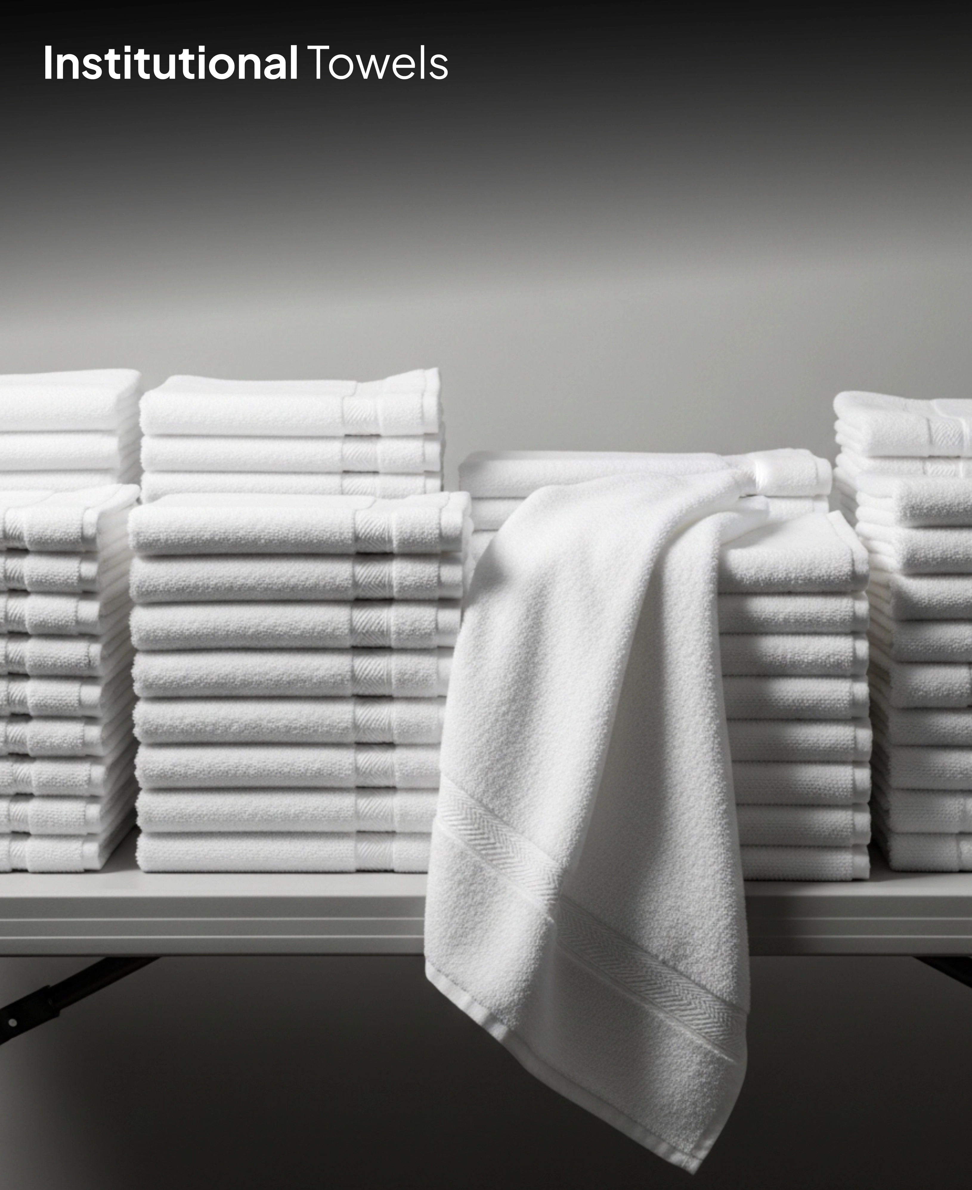 Folded white institutional towels on shelf